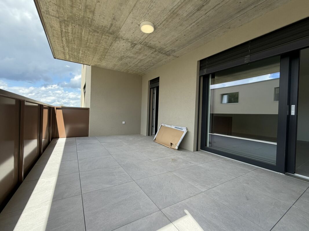 Überdachte Terrasse mit großformatigen Fliesen
