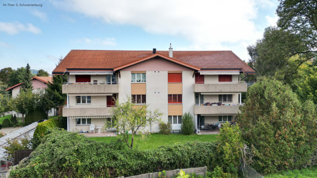 Mehrfamilienhaus mit roten Ziegeldächern und Balkonen