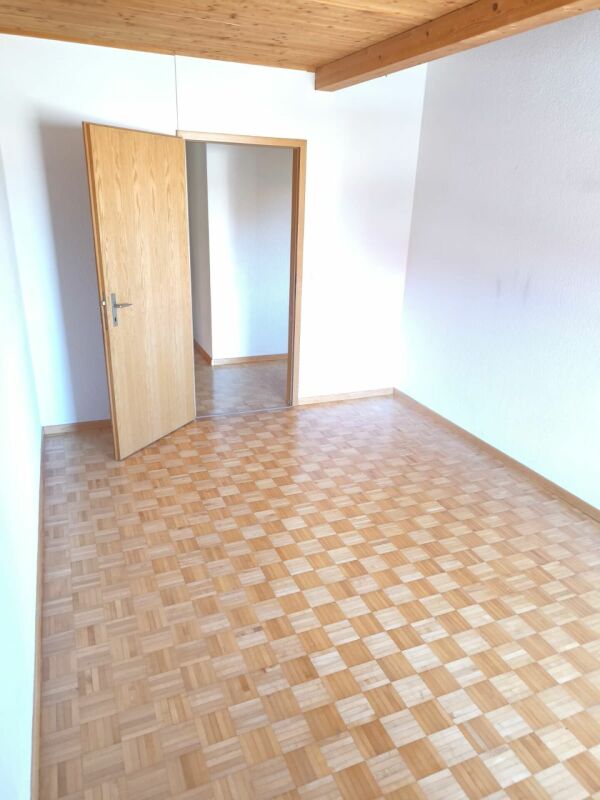 Leeres Zimmer mit Holzdecke und Schachbrettparkett