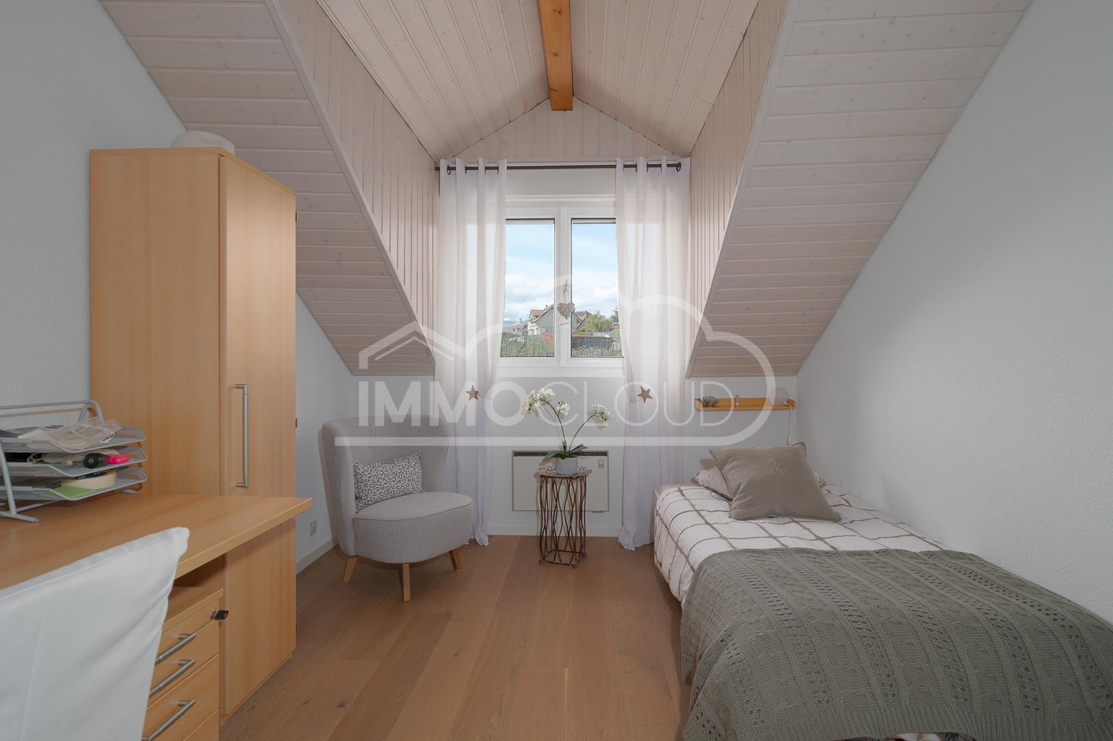 Dachzimmer mit Einzelbett und Arbeitsbereich