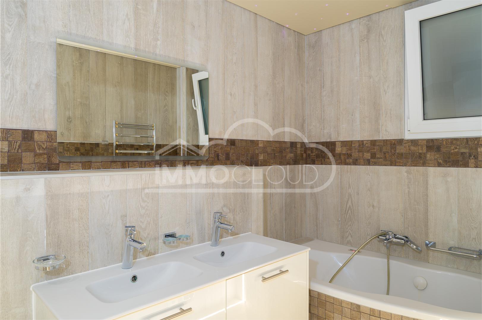 Helles Badezimmer mit Doppelwaschtisch und Badewanne
