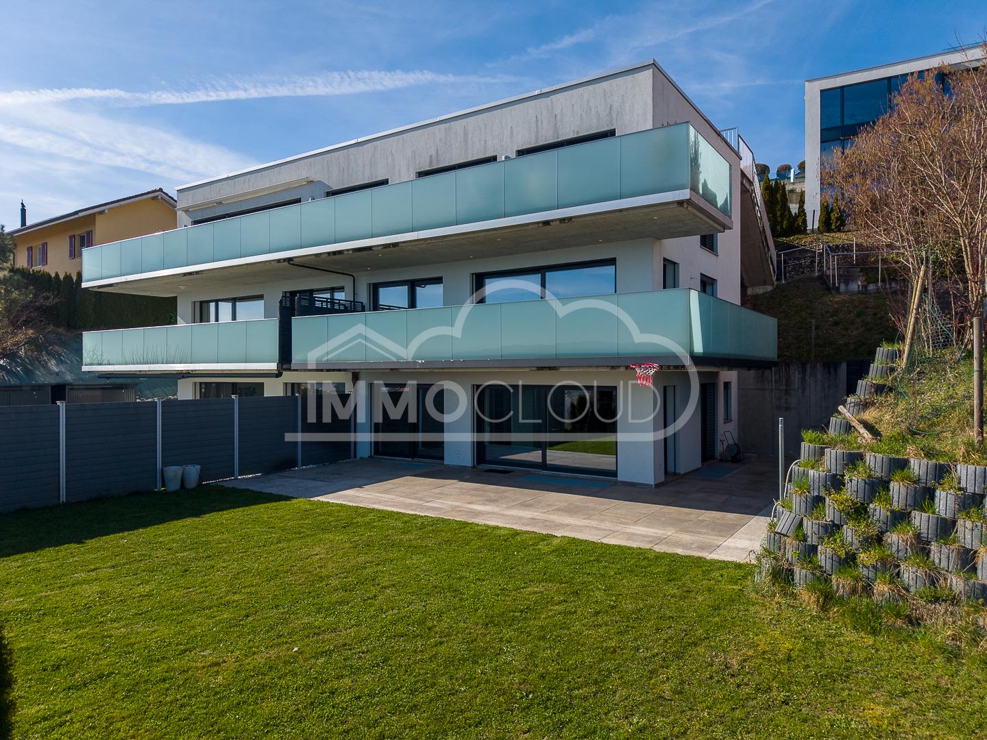 Moderne Außenansicht mit Balkon und Garten
