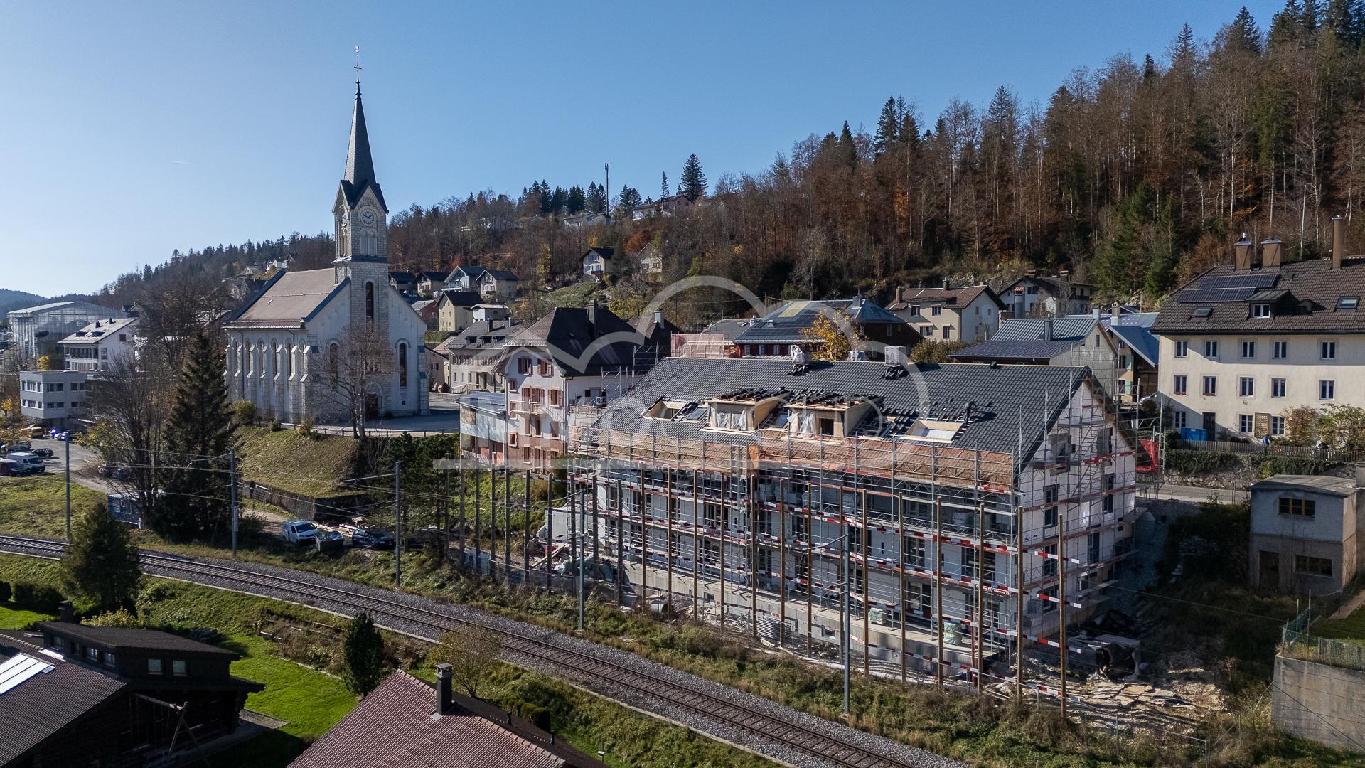 Ortsansicht mit Kirche und Baugerüst