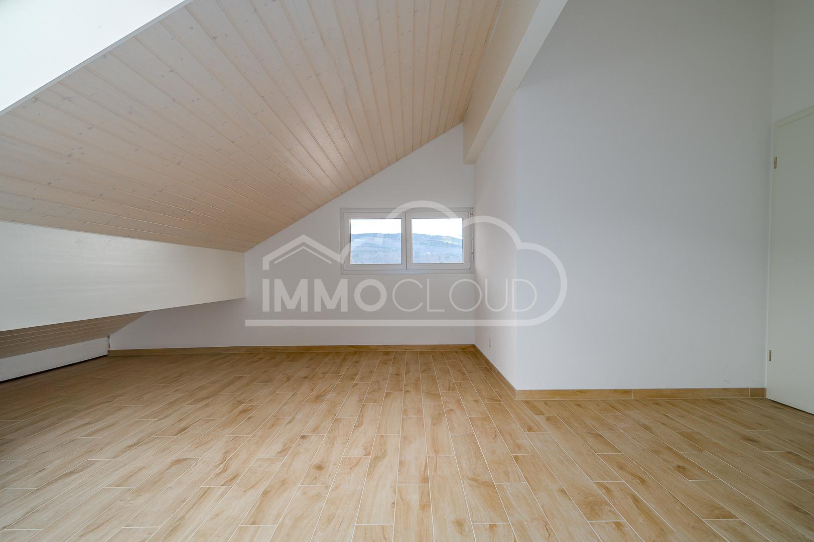 Leerer Dachraum mit Holzdecke und Fensterblick