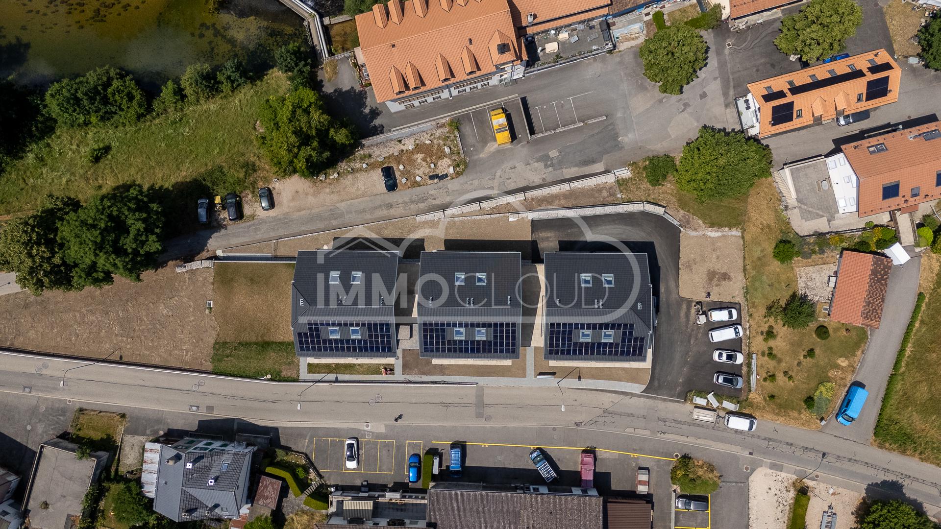 Luftaufnahme einer Wohnanlage mit Solardächern