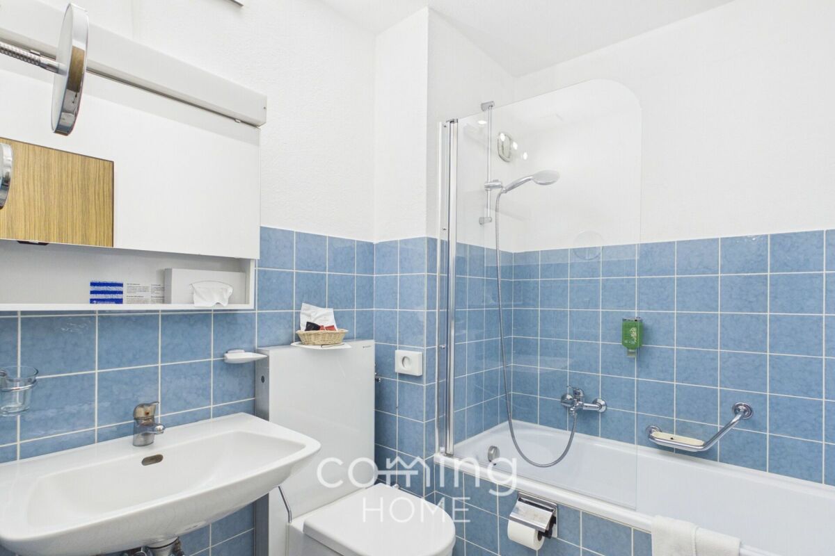 Badezimmer mit Badewanne und blau gefliesten Wänden