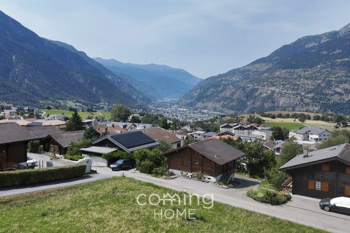 Panoramablick über ein alpines Tal mit Wohnhäusern