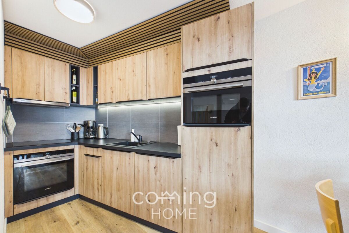 Moderne Küche mit Holzoptik und dunklen Arbeitsflächen