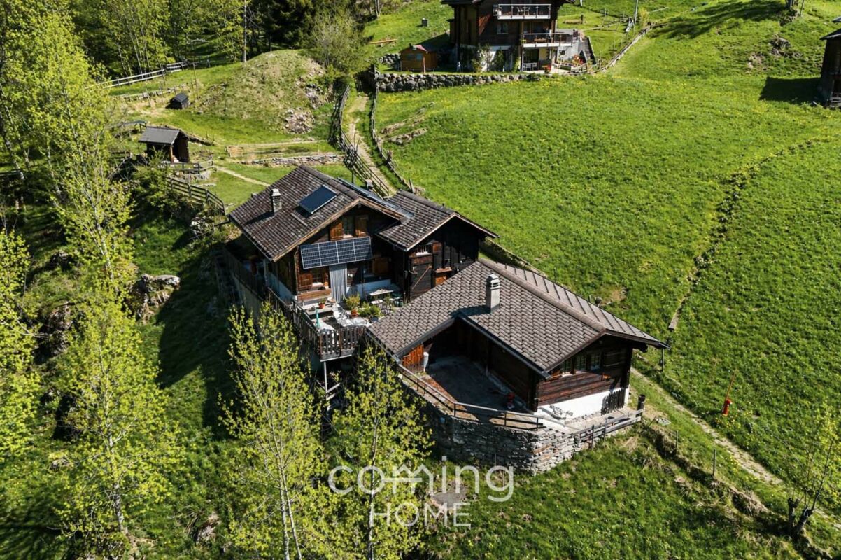 Alpines Anwesen mit Holzhäusern in grüner Hanglage