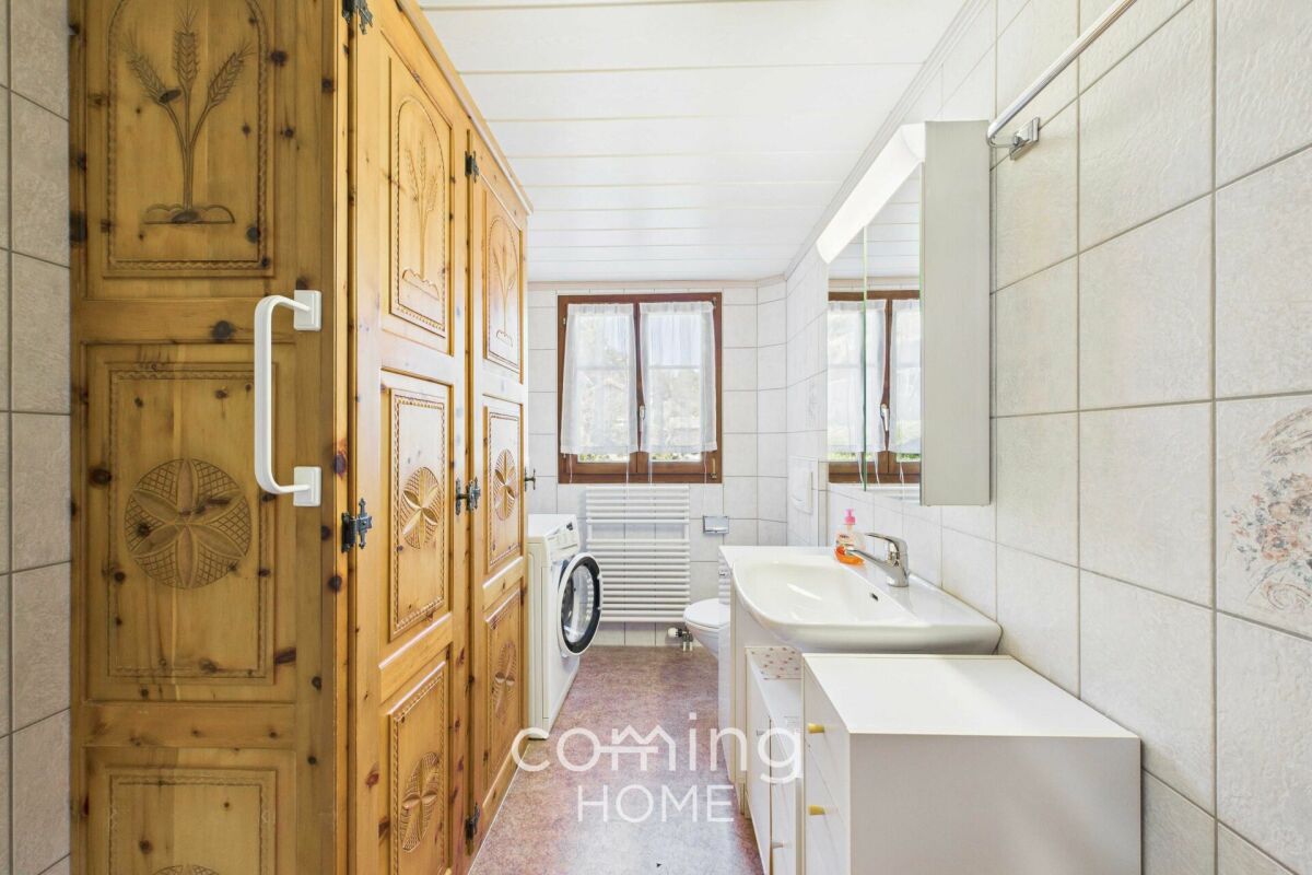 Badezimmer mit Holzschrank und Fenster