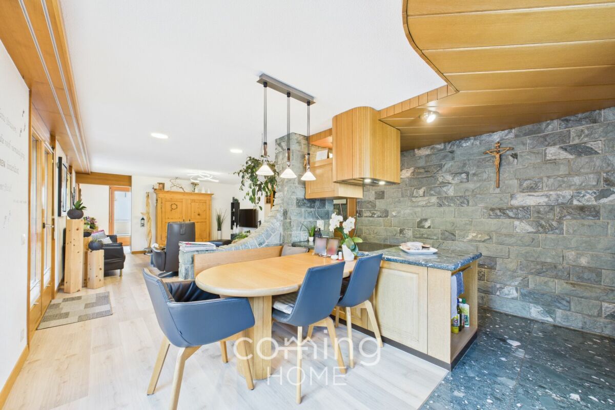 Offener Wohn- und Essbereich mit Holzoptik und Natursteinwand
