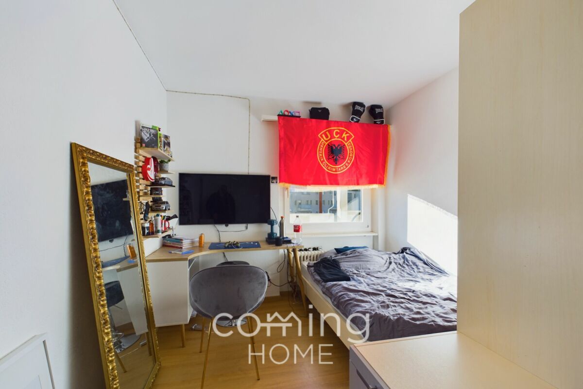 Kleines Schlafzimmer mit Schreibtisch und Bett