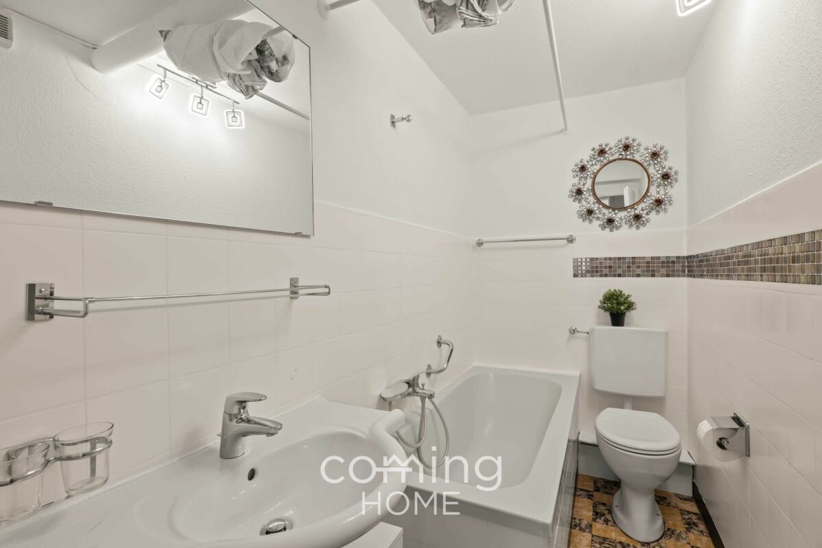 Kleines Badezimmer mit Wanne, Waschbecken und WC