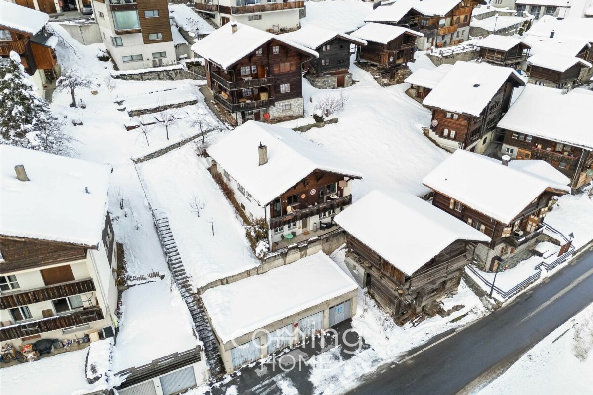 Verschneite Alpenhäuser aus der Luft
