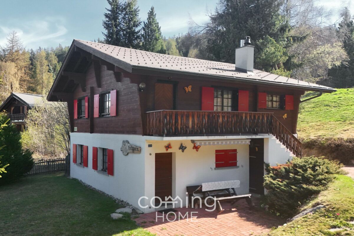 Alpines Chalet mit Balkon und roter Fensterläden