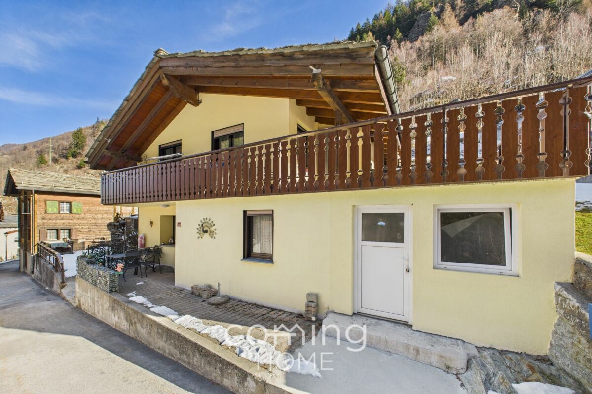 Alpenhaus mit Balkon und Bergkulisse