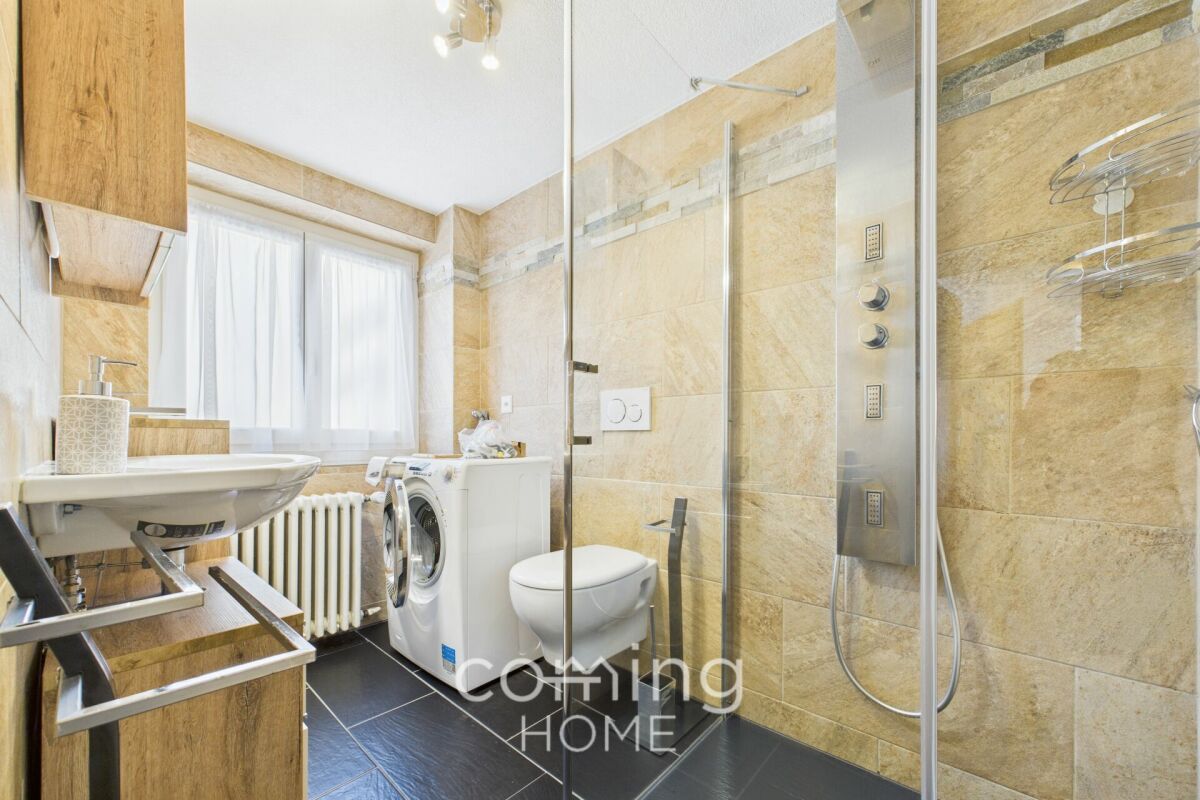 Modernes Badezimmer mit Dusche und Waschmaschine