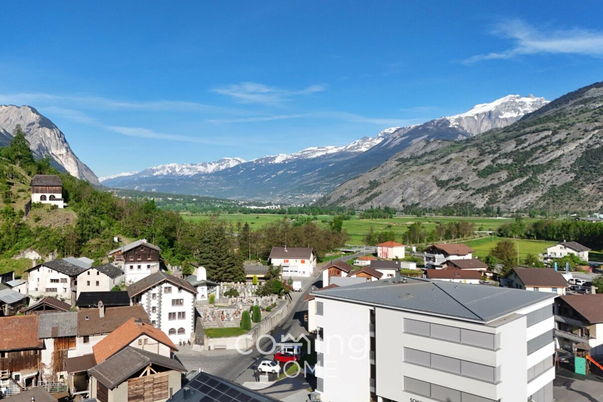 Alpenlandschaft mit Dorf und Bergen
