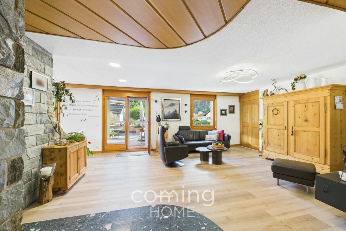 Helles Wohnzimmer mit Natursteinwand und Holzelementen