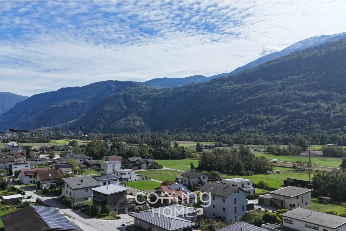 Bergtal mit Siedlung und weitem Landschaftsblick