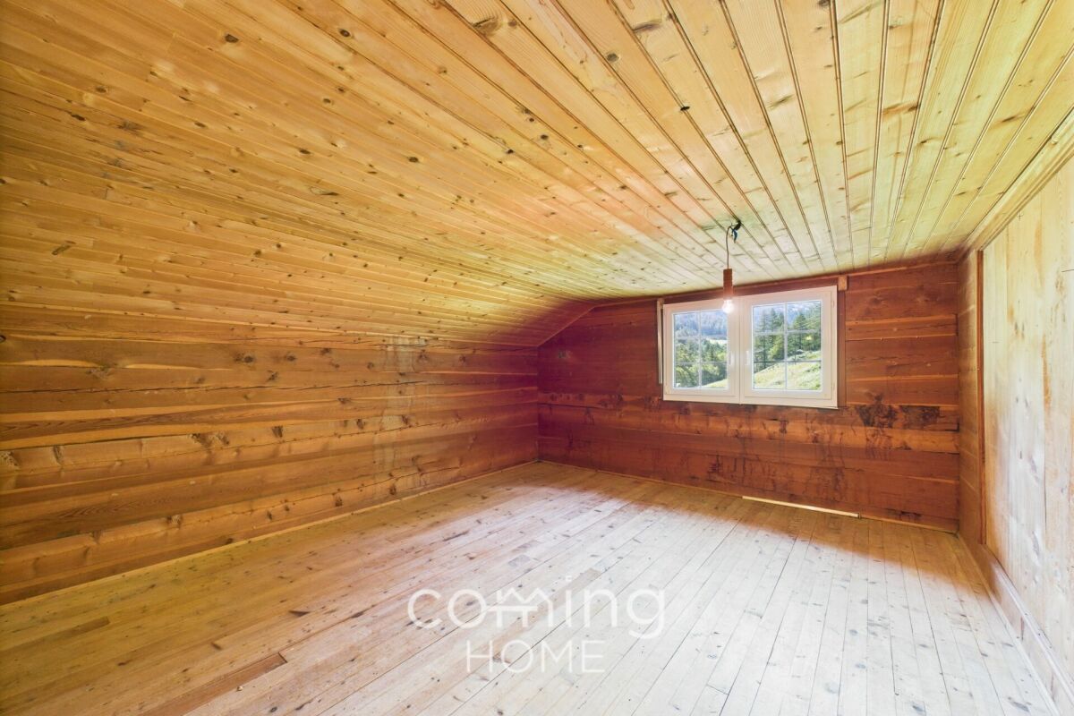 Leerer Holzraum mit Dachschräge und Fenster