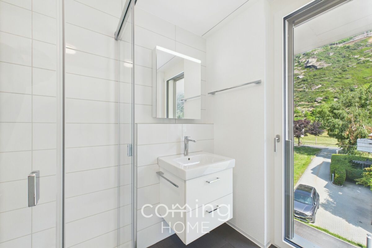 Modernes Badezimmer mit Glasdusche und Blick ins Grüne