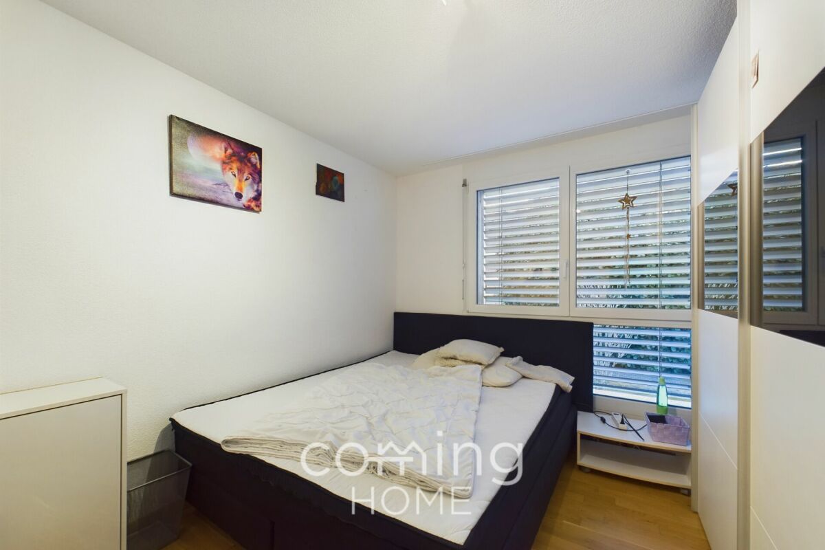 Kleines Schlafzimmer mit Bett und Fensterjalousien