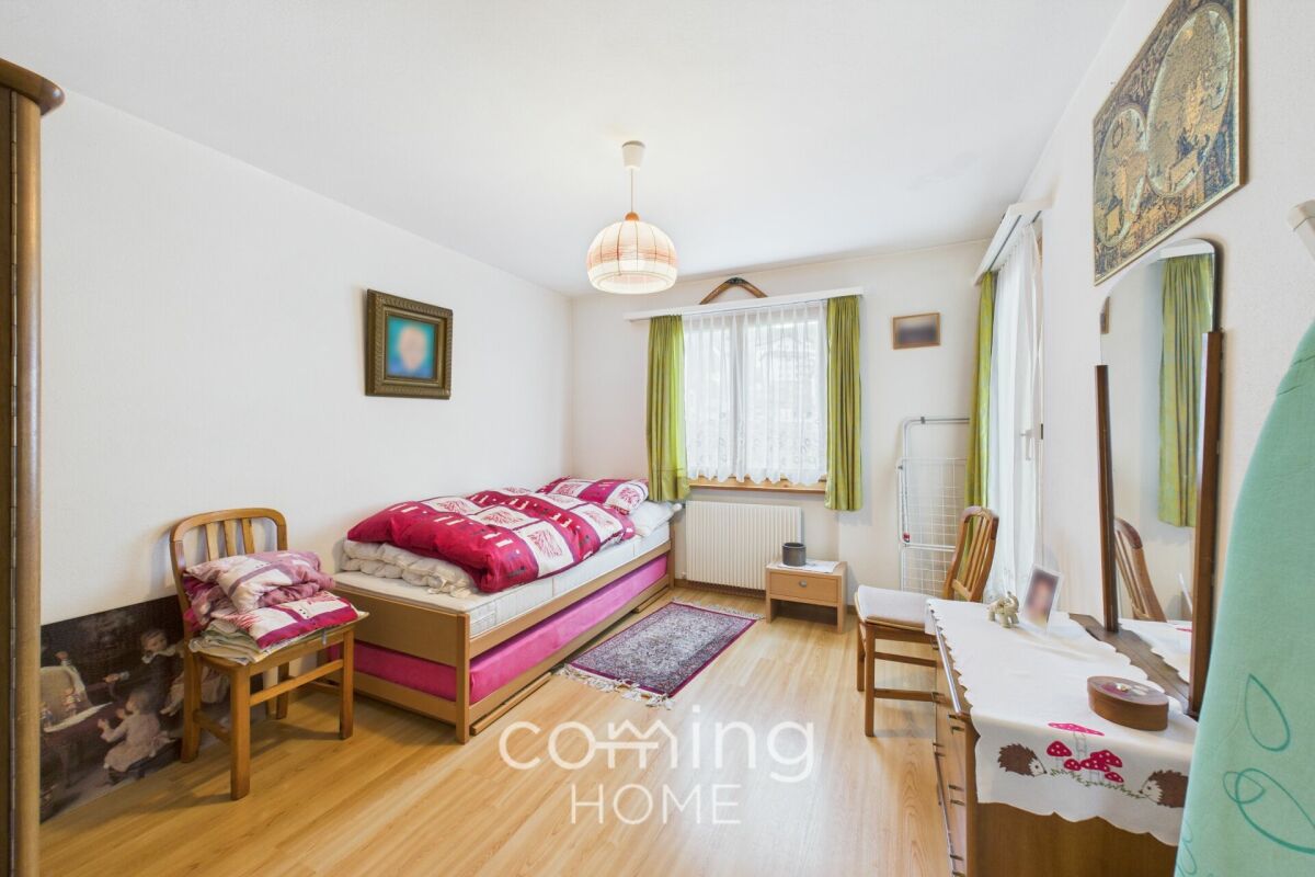 Helles Schlafzimmer mit Einzelbett und kleinem Arbeits-/Schminktisch