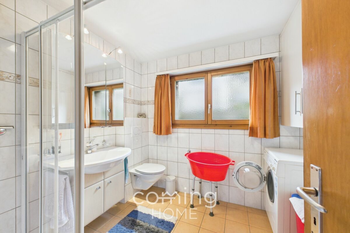 Badezimmer mit Fenster, Dusche, Waschmaschine und WC
