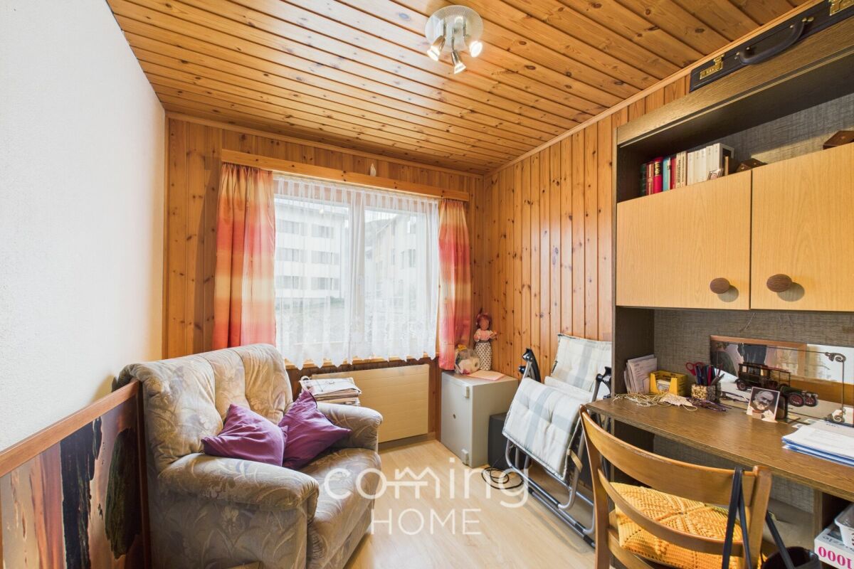 Kleines holzvertäfeltes Zimmer mit Arbeitsplatz und Sessel