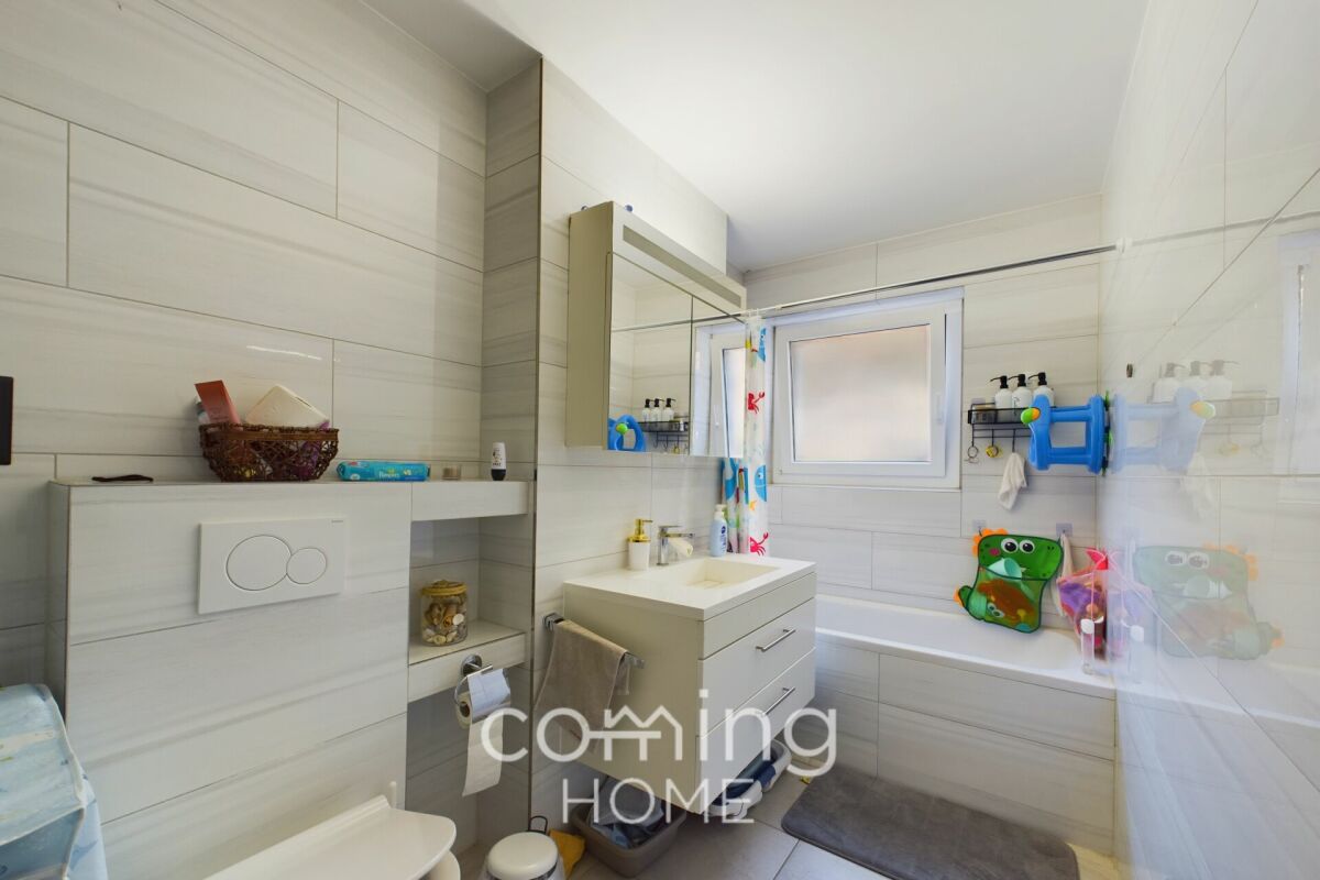 Helles, modernes Badezimmer mit Badewanne und Waschtisch