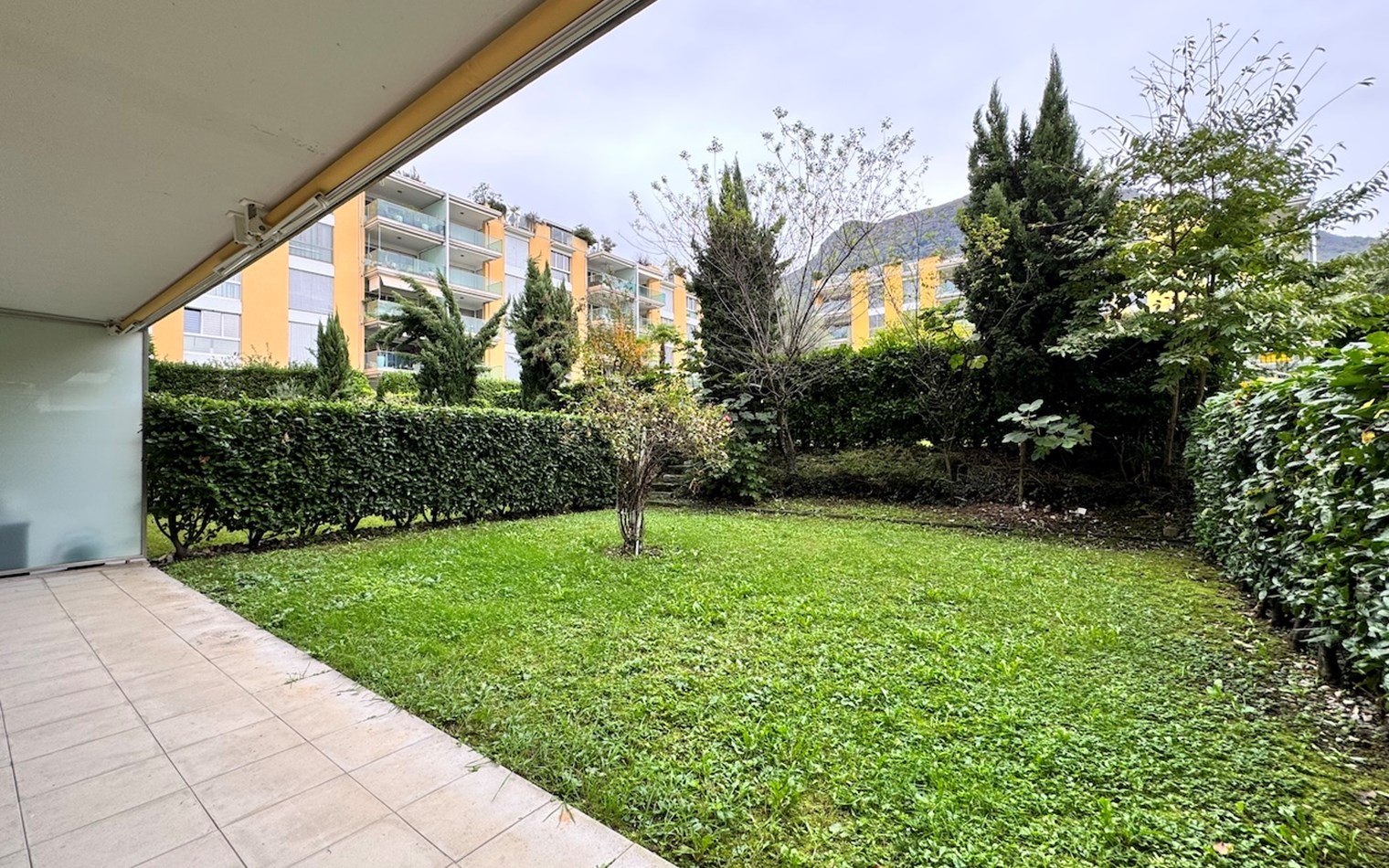Garten mit Terrasse und Blick auf Wohnanlage