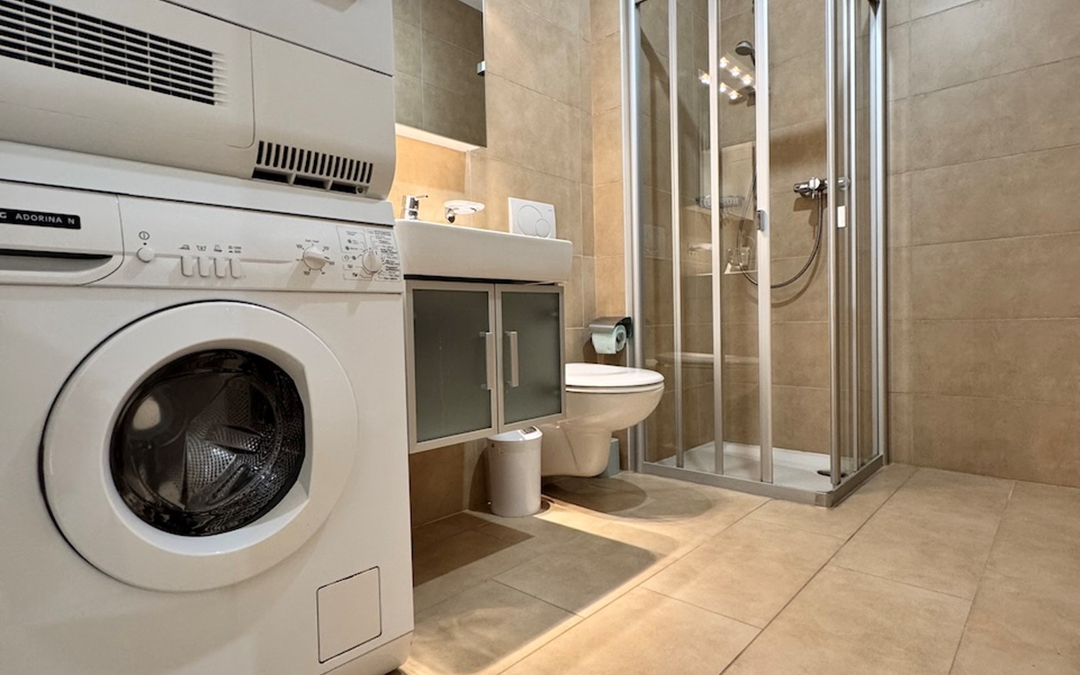 Modernes Badezimmer mit Waschtrockner und Dusche