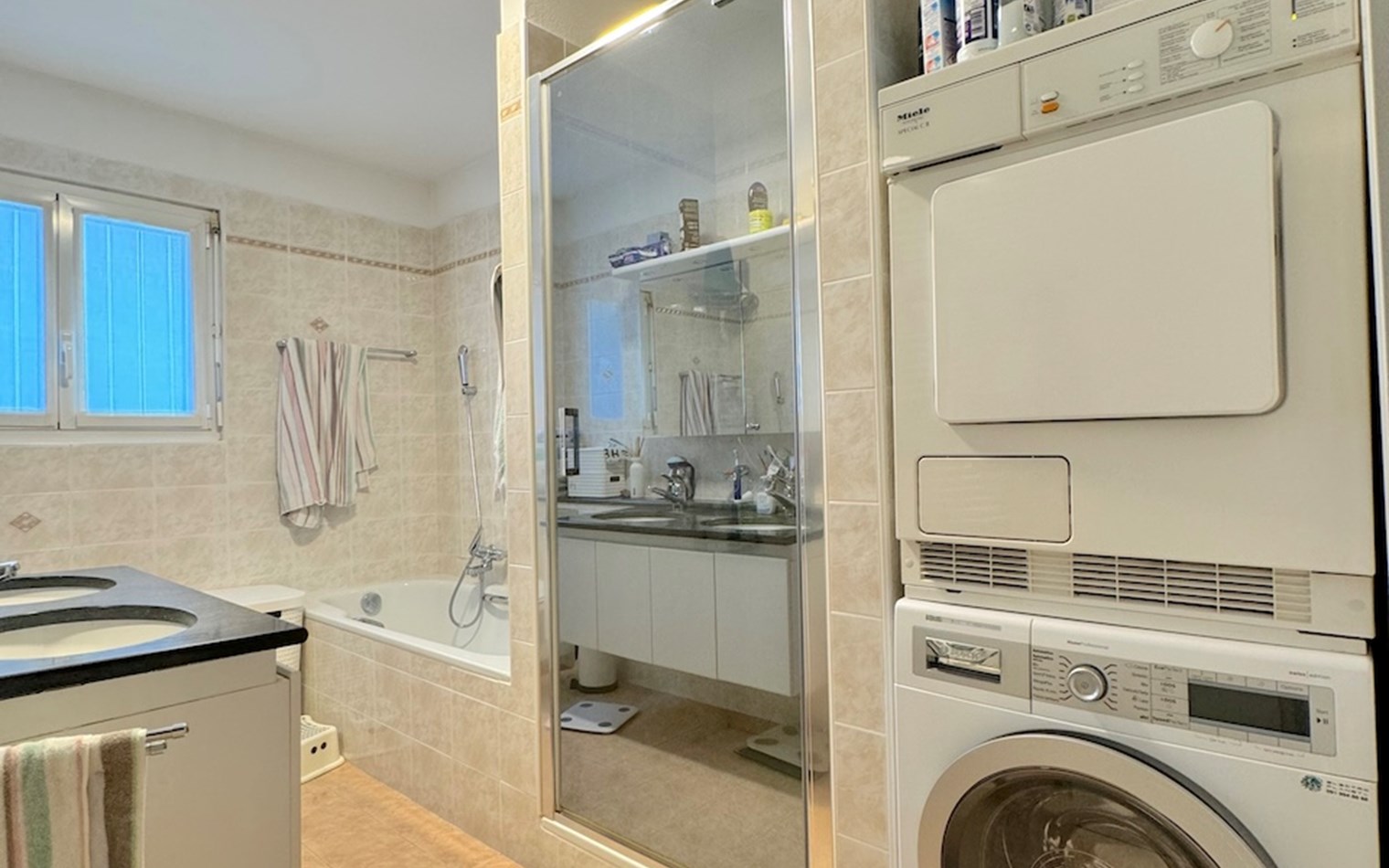 Badezimmer mit Waschtisch, Badewanne und Haushaltsgeräten