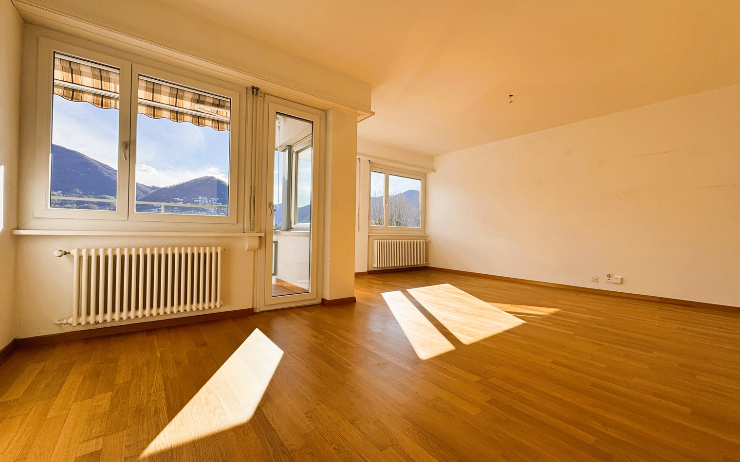 Helles, leeres Wohnzimmer mit Bergblick