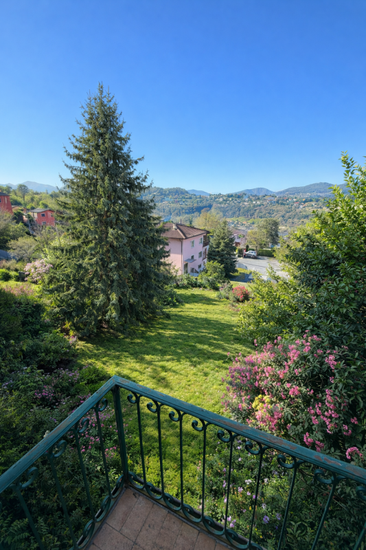 Blick von einem Balkon in eine grüne Hügellandschaft