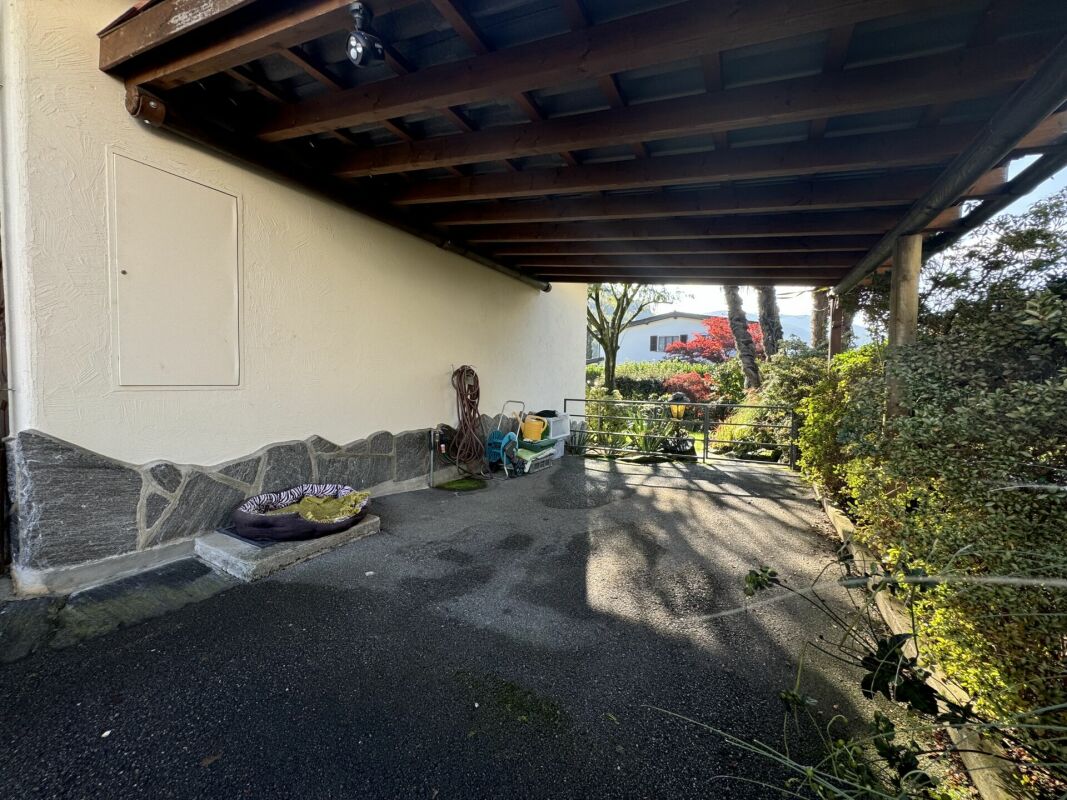 Überdachter Außenbereich mit Einfahrt und Gartenblick