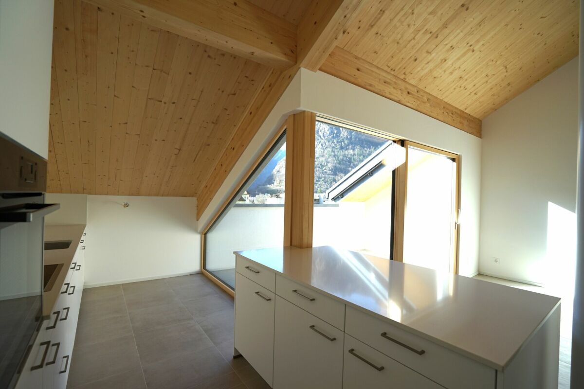 Dachgeschoss-Küche mit Holzdecke und Bergblick