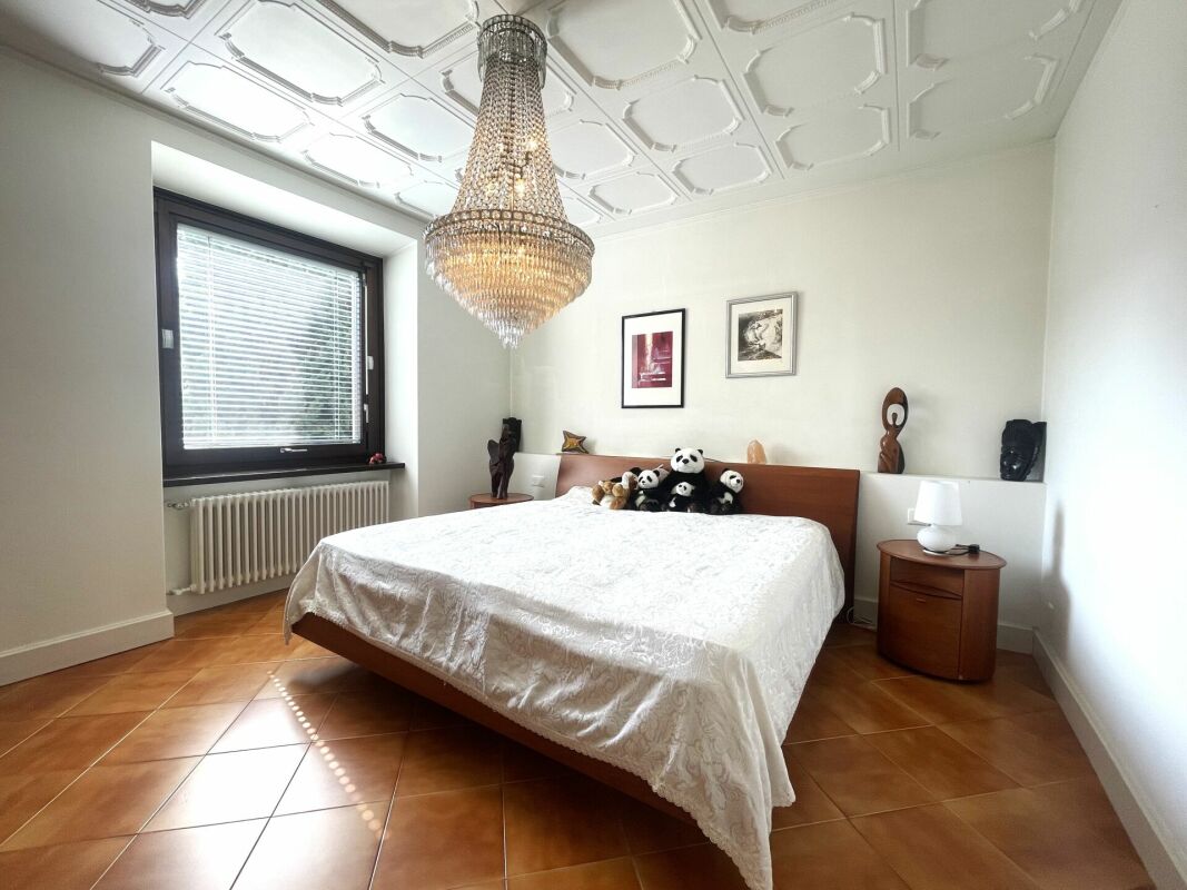 Schlafzimmer mit Kronleuchter und Fliesenboden