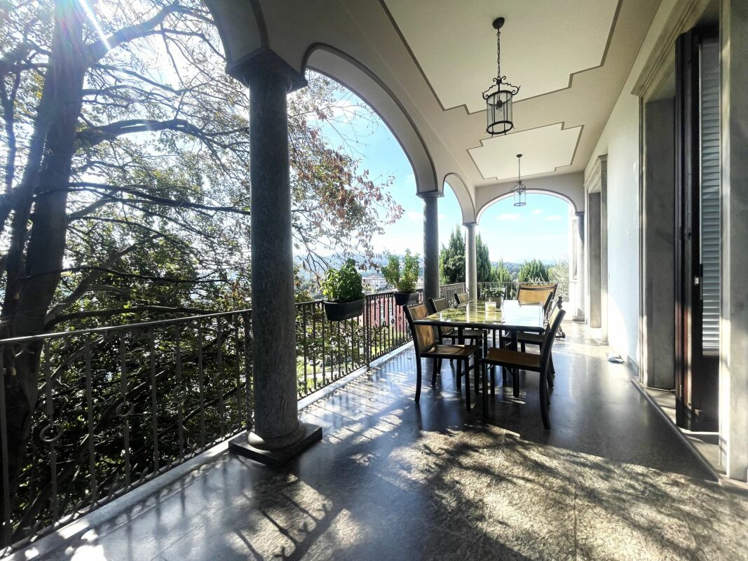 Überdachte Terrasse mit Säulen und Gartenblick