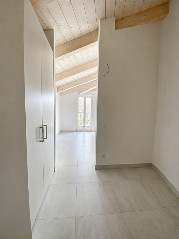Heller Flur mit sichtbaren Holzbalken und Dachschräge