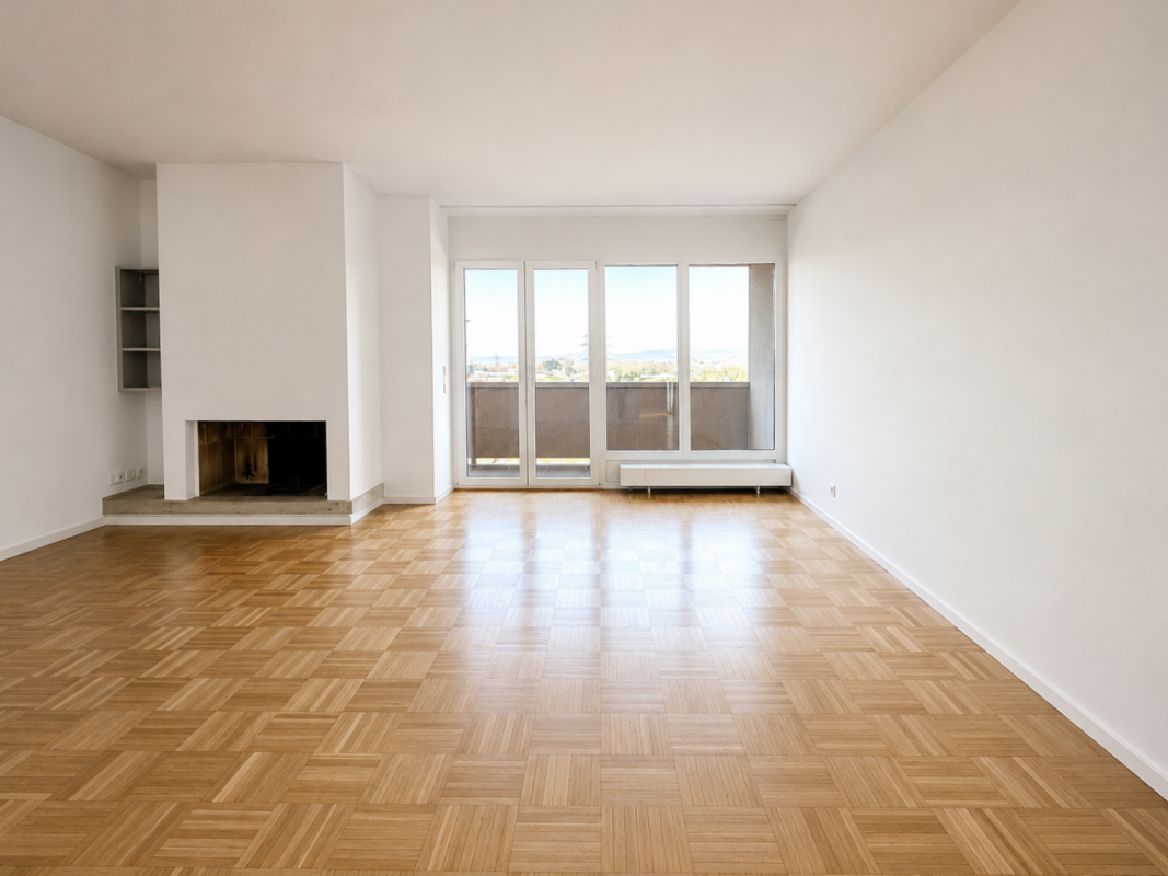 Leerer Wohnraum mit Kamin und Balkonblick