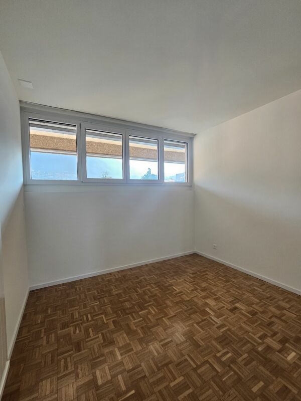 Leerer Raum mit Fensterband und Parkettboden