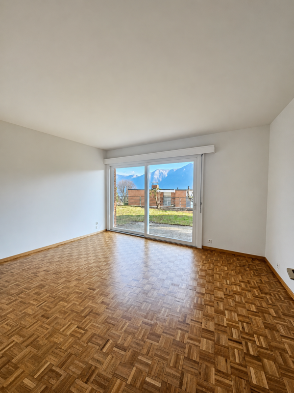 Leerer Wohnraum mit Balkon- bzw. Terrassentür und Bergblick