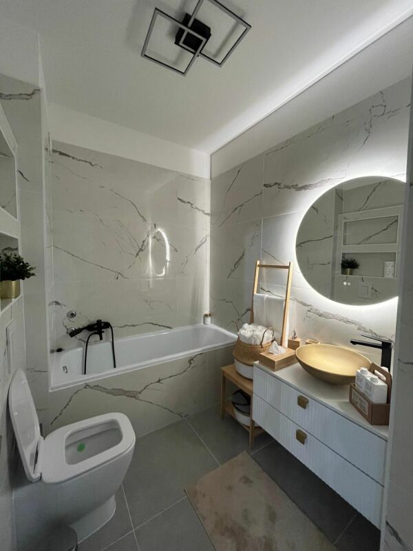 Modernes Badezimmer mit beleuchtetem Rundspiegel