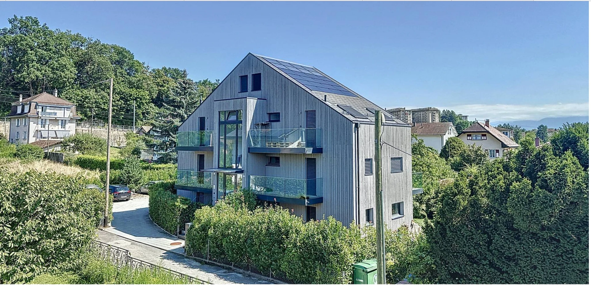 Moderne Wohnanlage mit Holzfassade und Solardach