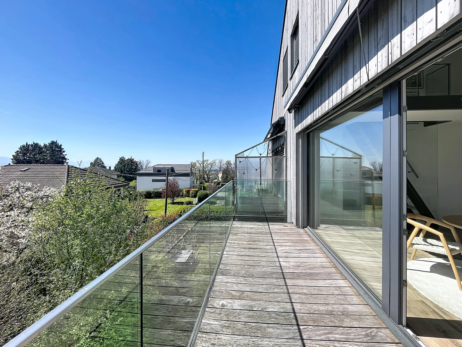 Balkon mit Holzdeck und Glasgeländer