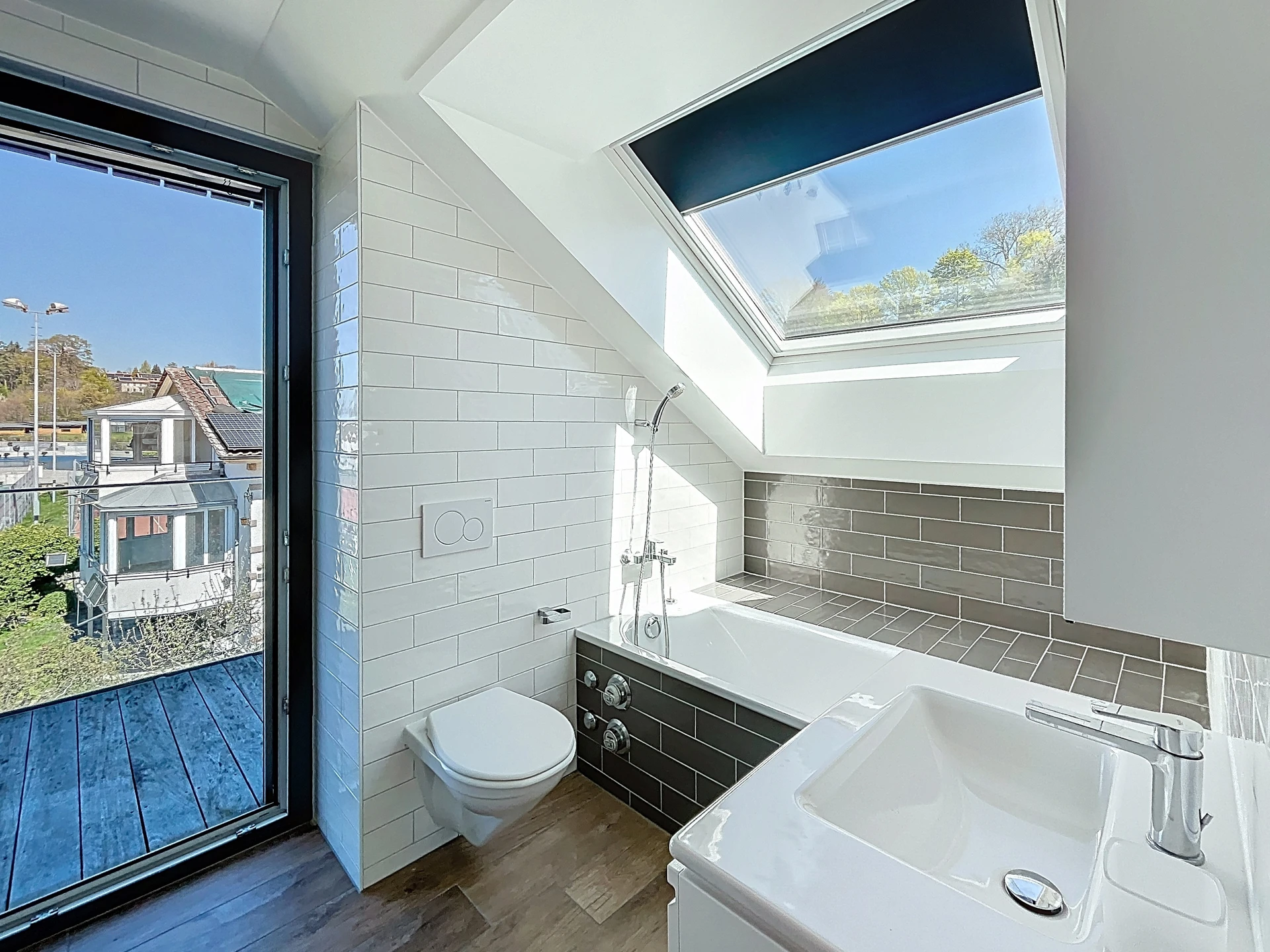 Helles Badezimmer mit Dachfenstern und Balkonzugang