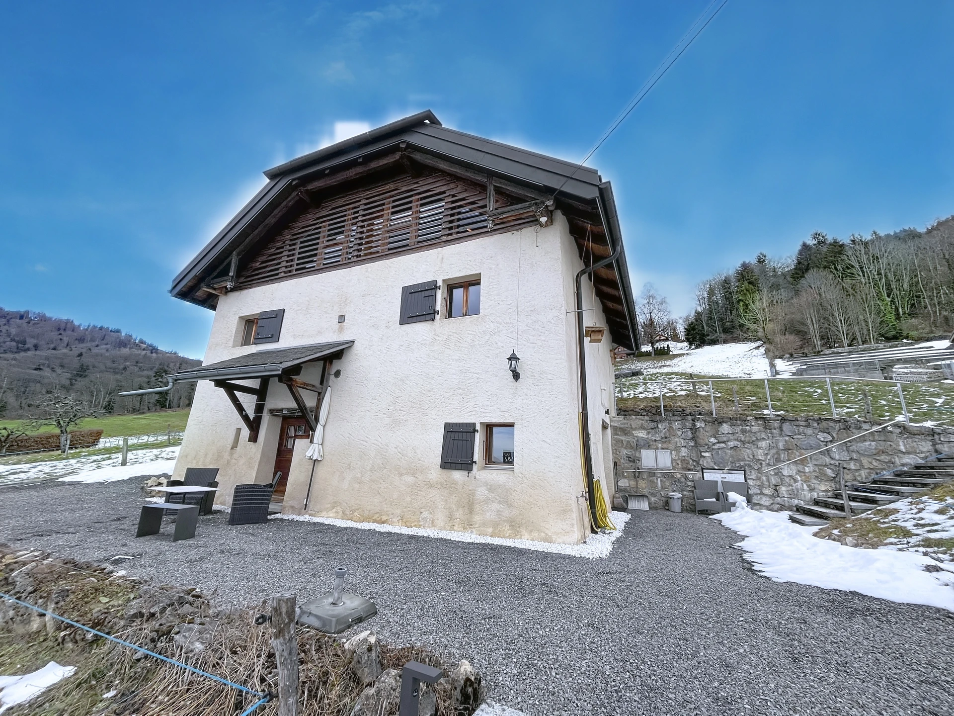 Alpenhaus mit Putzfassade und dunklem Steildach