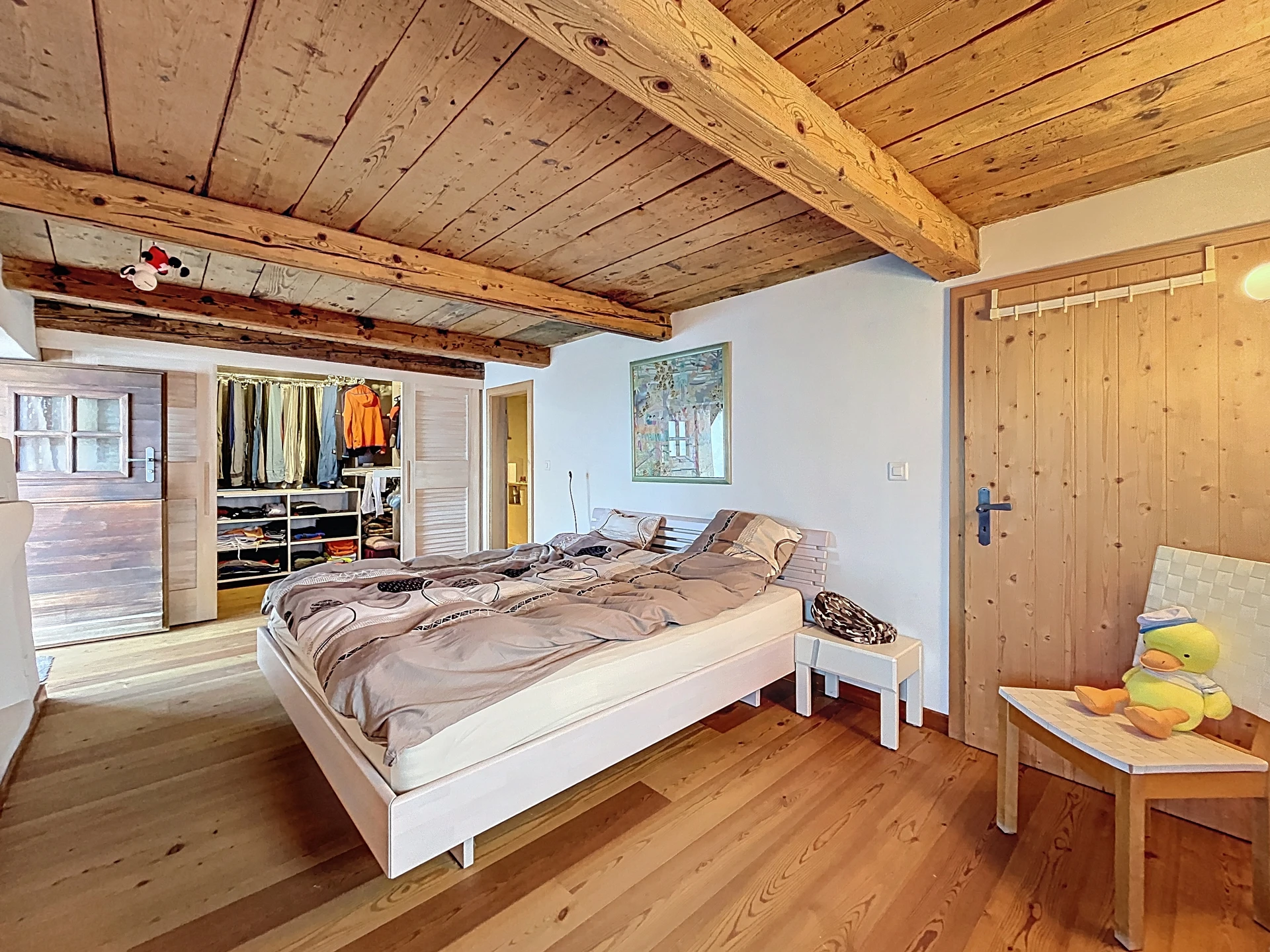 Rustikales Schlafzimmer mit Holzdecke und Ankleide